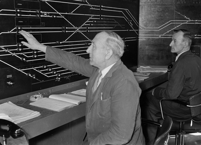 159685 Afbeelding van de treindienstleider bij het NX-bedieningstableau in het seinhuis (post T) van de N.S. te Eindhoven.